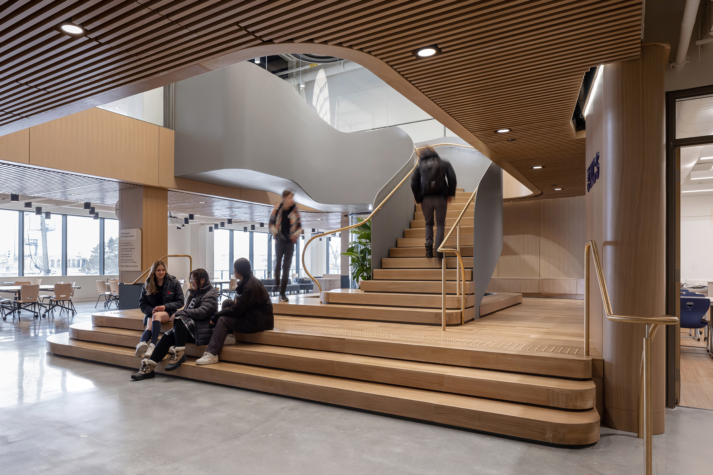 view of students sitting on steps of feature staircase