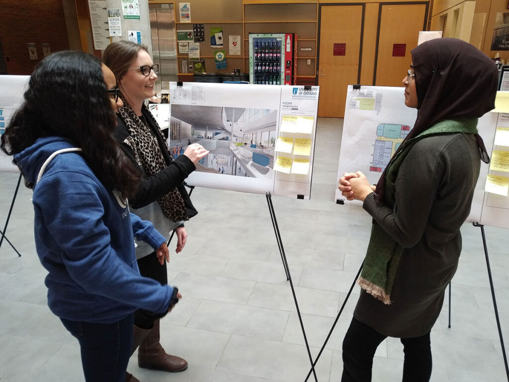 uoit consultations photo of girls at sticky note presentation boards